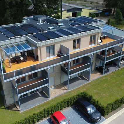 Modernes Haus mit Solaranlage großen Balkonen minimalistischer Architektur und geparkten Autos