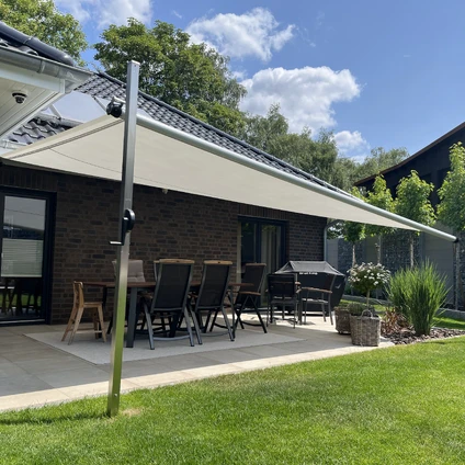 Modernes Haus mit Veranda und Markise auf einer sonnigen Rasenfläche mit Sitzgruppe